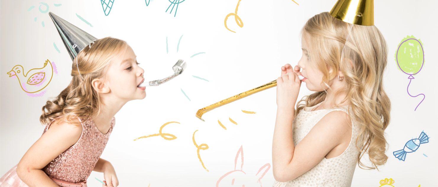 Deux petites filles en robe de fête et chapeau pointu s’amusent avec des cotillons lors d’un anniversaire, décor festif avec dessins colorés